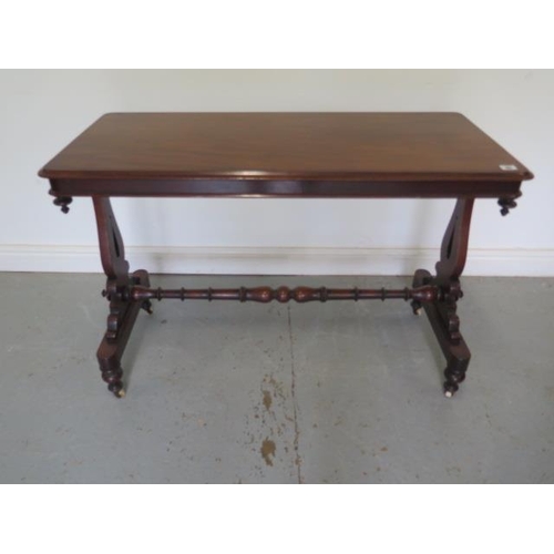 73 - A Victorian mahogany stretcher table with shaped twin pedestal supports united by a turned stretcher... 