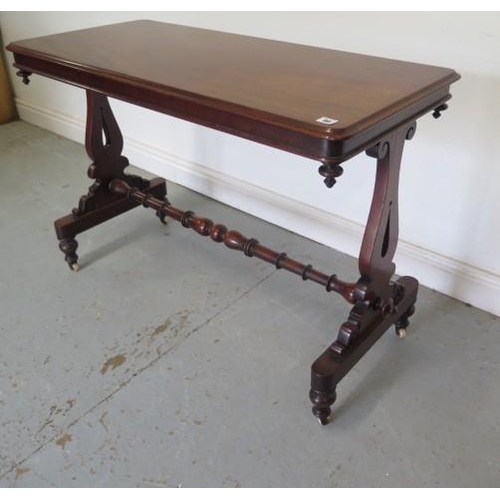 73 - A Victorian mahogany stretcher table with shaped twin pedestal supports united by a turned stretcher... 