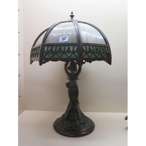 An Art Nouveau style bronze figural table lamp with a coloured glass shade, 52cm tall, will need wiring