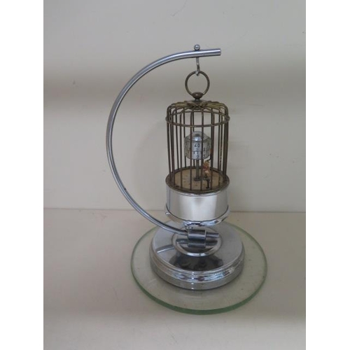 152 - A novelty bird in a cage chrome plated alarm clock, 22cm tall, in working order