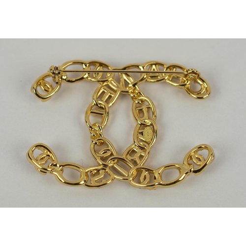 100 - CHANEL BROOCH, gilt metal, in the form of the Chanel logo, bearing letters reading Chanel Paris, ins... 