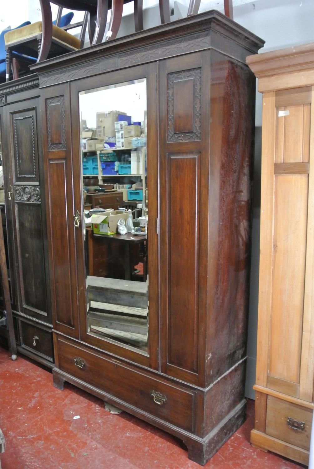 An antique Edwardian wardrobe with central mirror door & drawer base.