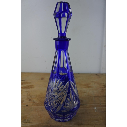 311 - A late 19th century/early 20th century tapering clear glass decanter cased in dark blue with cut inw... 