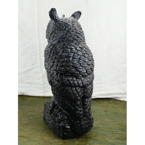 28 - A large plastic owl on a stone base.