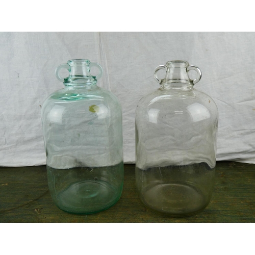 42 - Two vintage glass demijohn bottles.