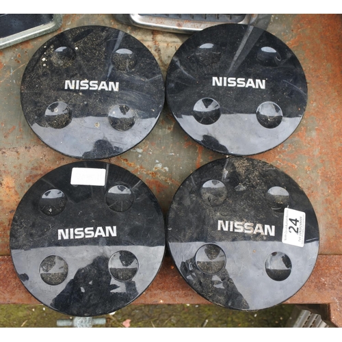 24 - A set of four Nissan car parts, measuring 17cms in diameter.