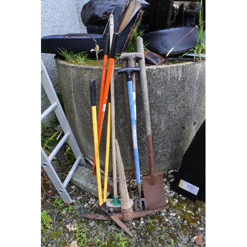 66 - An assortment of tools, pick axe, shovels, rakes and more.