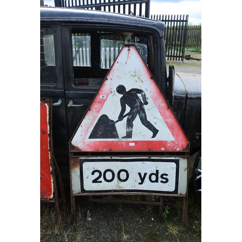 84 - A large metal road works sign, measuring 140cm in height.