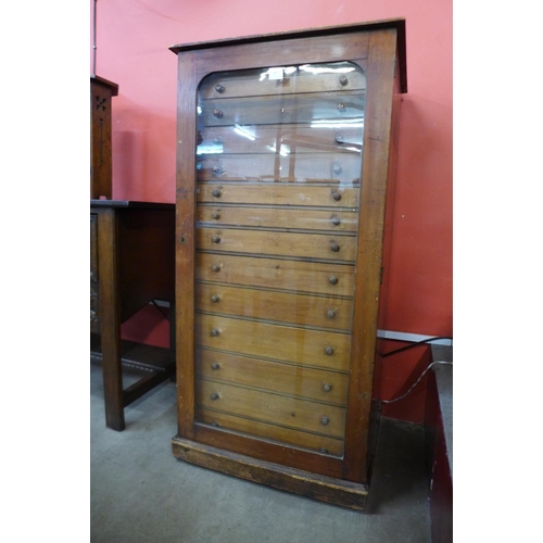 26 - A Victorian stained pine museum collectors cabinet, with single glazed door revealing thirteen drawe... 