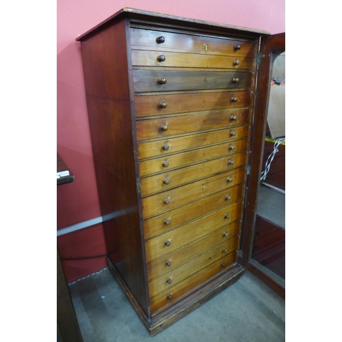 26 - A Victorian stained pine museum collectors cabinet, with single glazed door revealing thirteen drawe... 