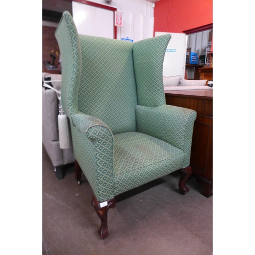 35 - A Victorian mahogany and green fabric upholstered wingback armchair