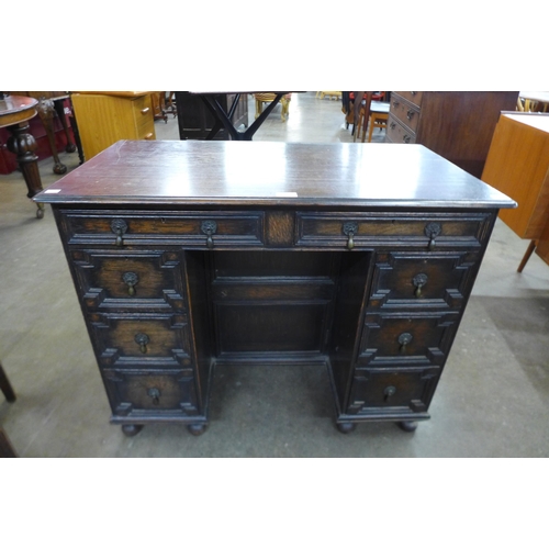40 - A Jacobean Revival oak geometric moulded kneehole desk