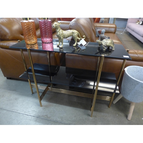 1348 - A black glass and gold two tier console table