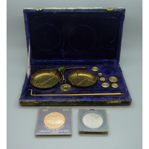 653 - A cased set of jeweller's scales and two coins, (scales lacking one weight)
