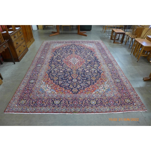 20 - A Persian red ground Kashan rug, 387 x 268cms