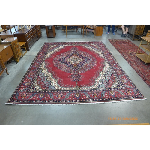 22 - A Persian red ground Tabriz rug, 393 x 303cms