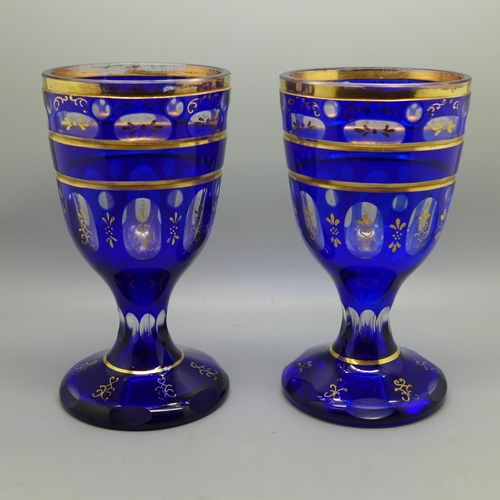 607 - A pair of Bohemia blue glass goblets with gilt decoration, 17.5cm
