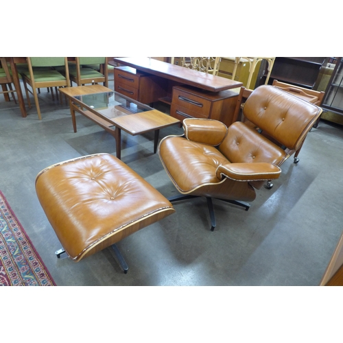 21 - A Charles & Ray Eames style tan leather armchair and stool