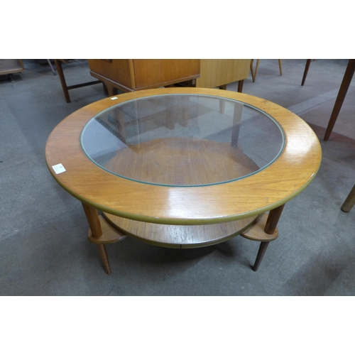 55 - A circular teak and glass topped coffee table
