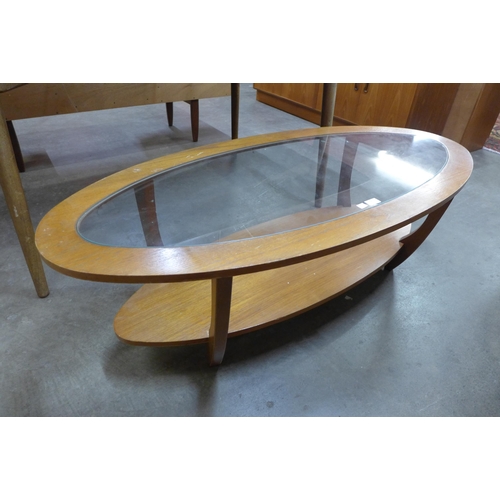 56 - An oval teak and glass topped coffee table