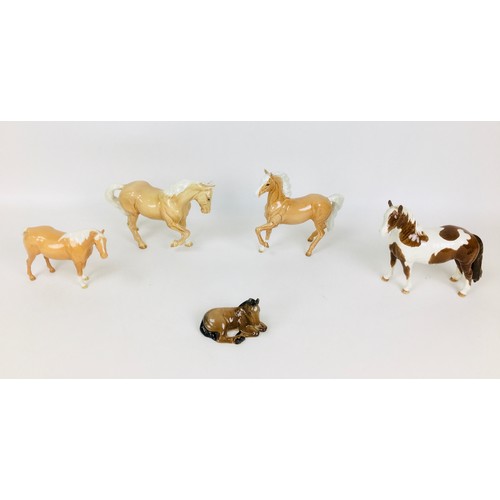 34 - A group of five Beswick horse figurines, comprising three palomino horses, one standing with repaire... 