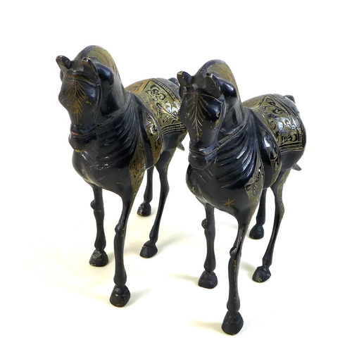 11 - A pair of lacquered brass horses, likely 19th century Indian or Chinese, the etched back design deta... 