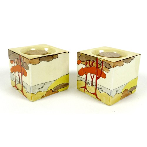 84 - A pair of Clarice Cliff bizarre cuboid candlesticks, hand painted in the Coral Firs pattern, shape n... 