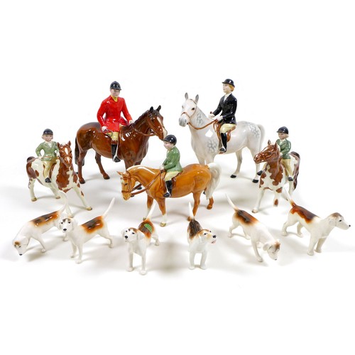 A Beswick Hunting Family Group, comprising 'Huntsman', style two, standing, model 1501, brown gloss, 21cm high, 'Huntswoman', style two, standing, model 1730, grey gloss, 21cm high, two 'Girl on Pony', model 1499, skewbald gloss, one a/f with damaged legs, each 14cm high, 'Boy on Pony', model 1500, palomino gloss, 14cm high, and six Foxhounds, models 941, 942, 2263, 2624, and 2265, white, tan and black gloss, each approximately 7cm high. (11)