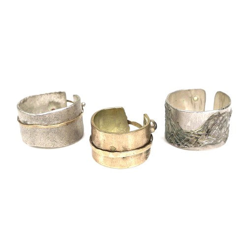 310 - A group of three modern design rings by Bek Genery, all of open design, one gold, unmarked and untes... 