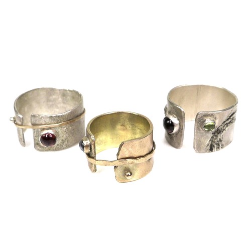 310 - A group of three modern design rings by Bek Genery, all of open design, one gold, unmarked and untes... 