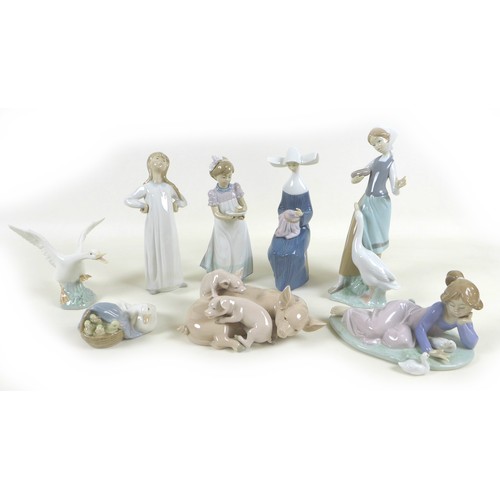 30 - A collection of Lladro figurines, including 'Girl with Duck', SKU 01001052, 25cm high, a sitting nun... 
