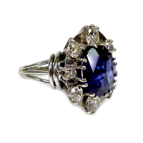 304 - A sapphire and diamond dress ring, the oval geometric cut royal blue sapphire of approximately 12 by... 
