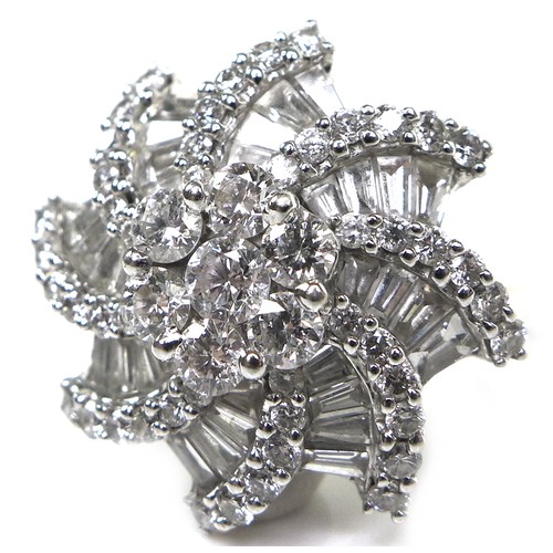 301 - An 18ct white gold and diamond flowerhead dress ring, set centrally with a flowerhead of seven round... 