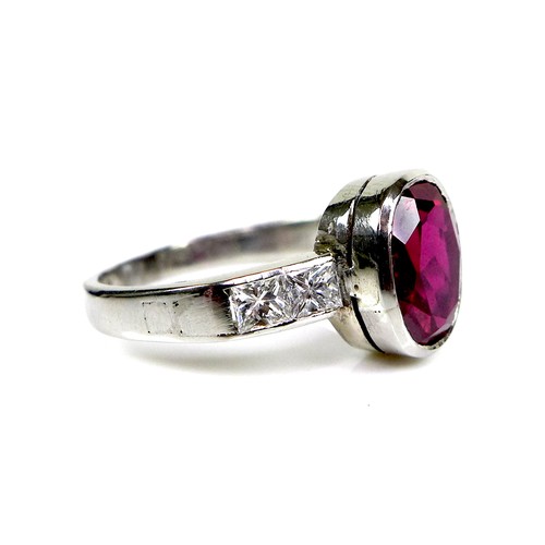 292 - A platinum, ruby and diamond ring, the central oval cut ruby measuring approximately 9.3 by 7.4 by 5... 