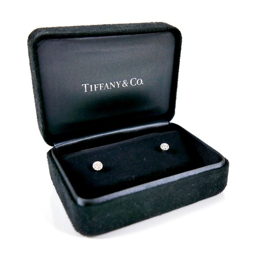 A pair of Tiffany & Co Soleste platinum and diamond stud earrings, of flowerhead form, each with central brilliant cut stone, 3mm, 0.1ct, surrounded by twelve smaller brilliant cut stones, each 1mm, 0.005ct, 5mm diameter, 14mm long overall, with sprung butterflies, 8mm, in black suede presentation box, and outer branded cardboard box, purchased from Tiffany & Co UK online shop, April 2018.