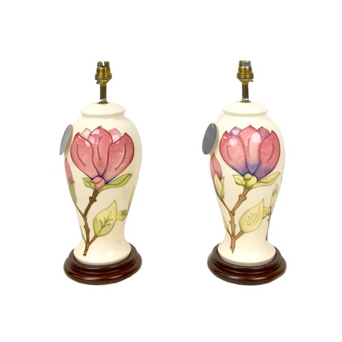 18 - A pair of late 20th century Moorcroft magnolia pattern electric lamp bases, both 37cm high overall. ... 