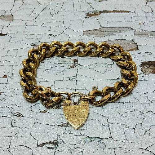 128 - A 9ct gold diamond cut curb bracelet, heart shaped padlock clasp, safety chain, hallmarked 56.69g