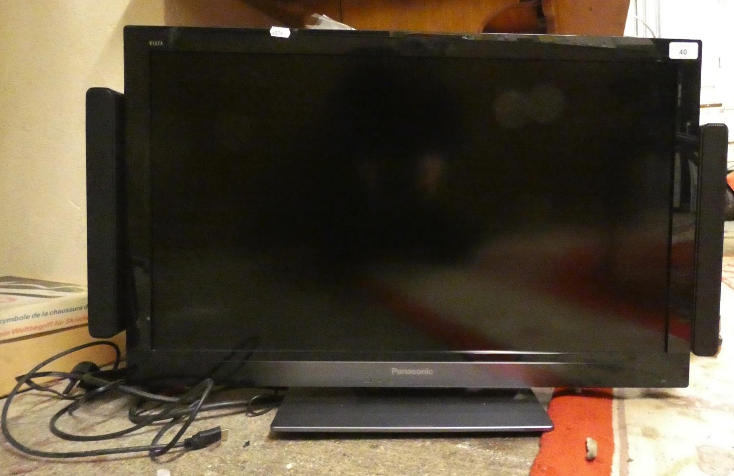 A Panasonic TX-L32E30B television with external speaker system, hand set.