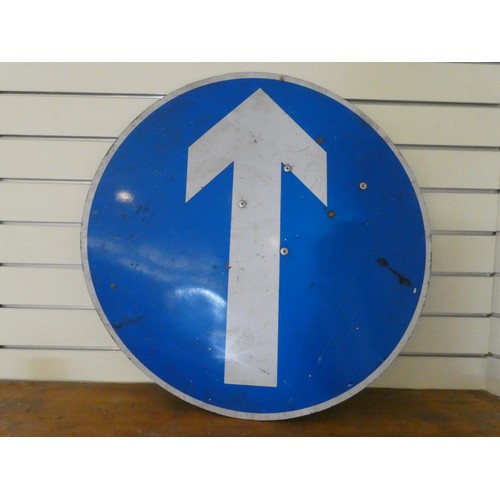 134 - A circular white on blue plastic arrow direction sign, diameter 75 cm.