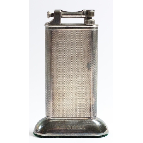 105 - Dunhill, a vintage silver plated petrol table lighter, the arm with Reg No 737438, engine turned bod... 