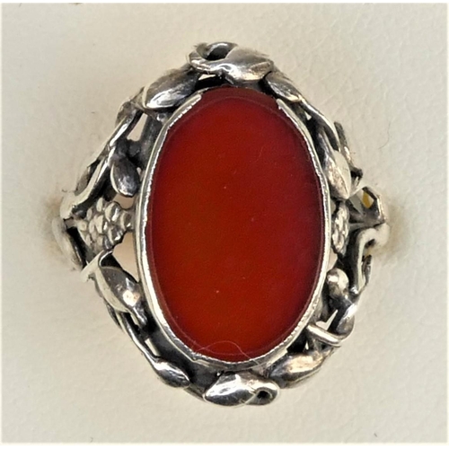 129 - An Arts & Craft cornelian and silver ring, with floral surround, size M