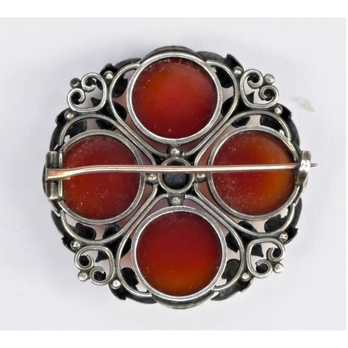 130 - An Arts & Crafts cornelian and silver brooch, collet set with four cabochon stones, 38mm diameter