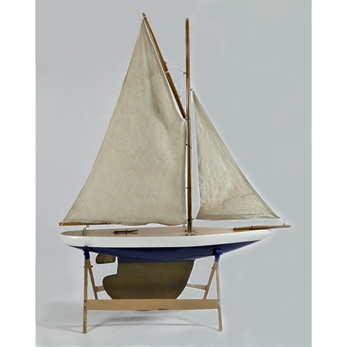 194 - A vintage solid wood gaff rigged pond yacht with blue hull and brass keel and rudder, 65 x 82cm.