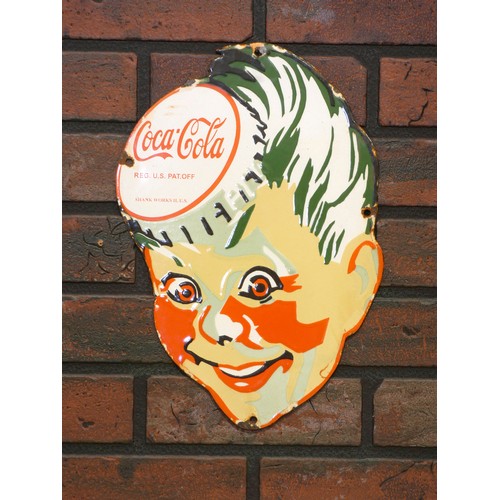 335 - A vitreous enamel Coco-Cola sign, depicting a child's face with a bottle cap,  23cm x 34.5cm