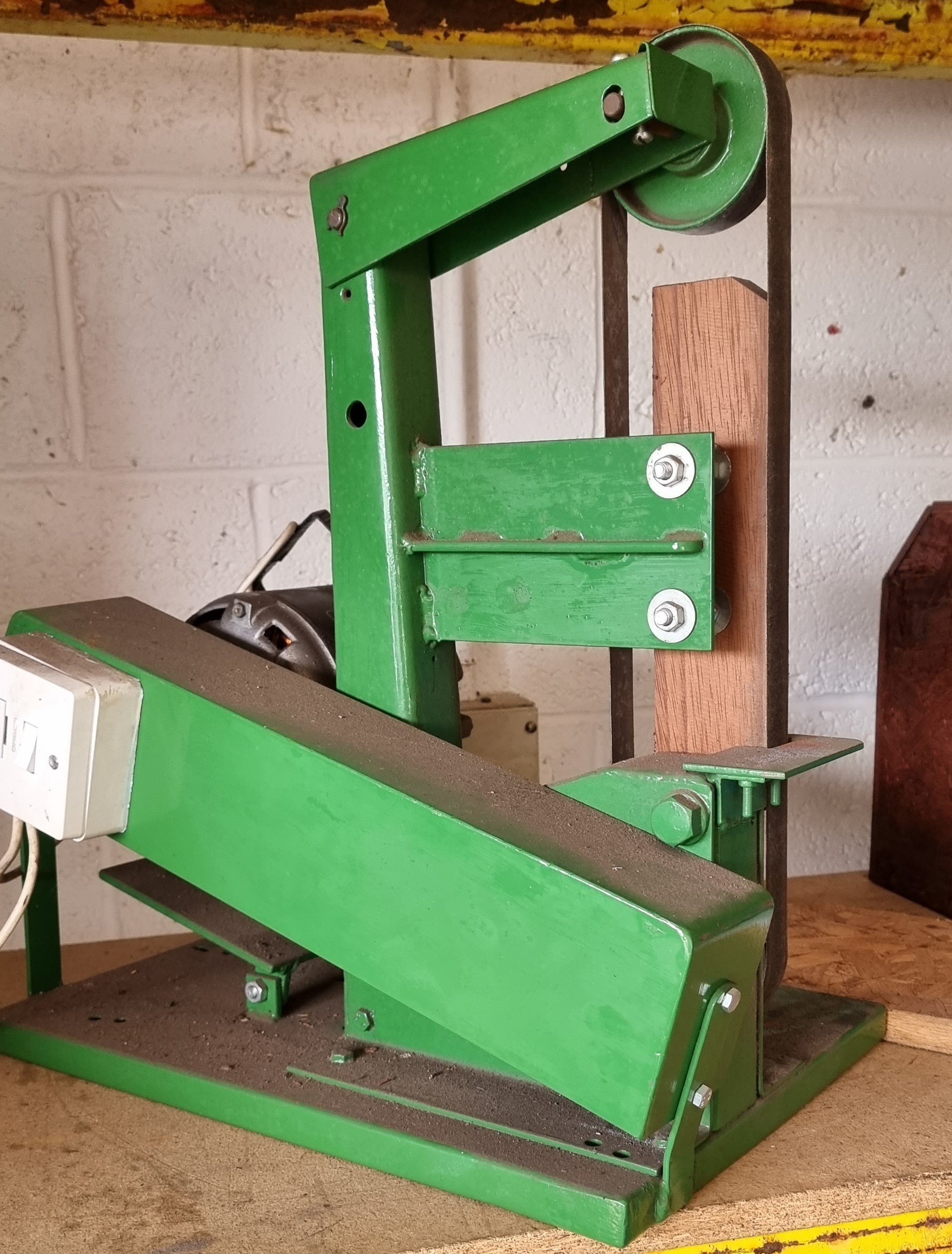 A bench mounted belt sander, 54cm high
