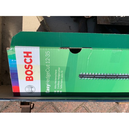 14 - A Bosch Easy Hedge Cut 12-35 hedge trimmer, boxed, together with hand saws and an animal trap, in a ... 