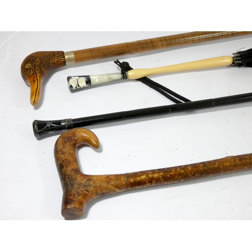 22 - Two Victorian parasols, together with a hazel shafted walking stick and a carved wood ducks head wal... 