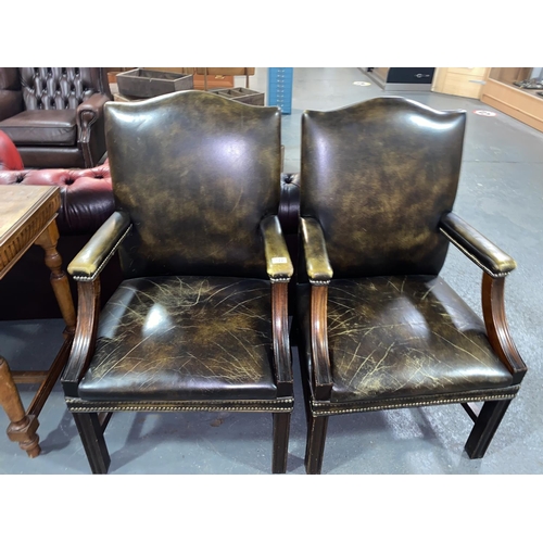 122 - A pair of green leather office armchairs
