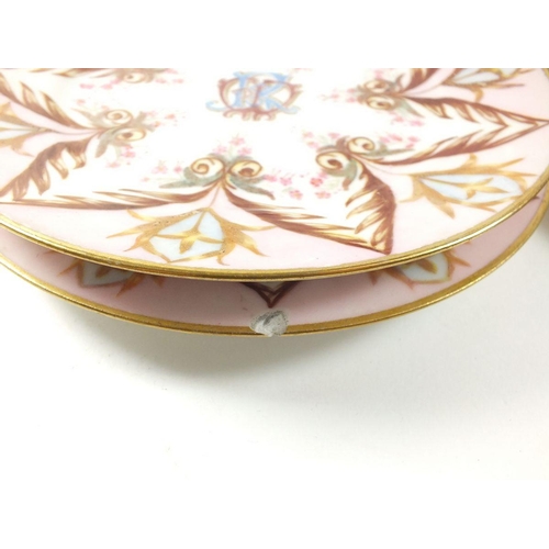 15 - A set of nine 19th century tea plates painted in pink and gilt with monogram to centre