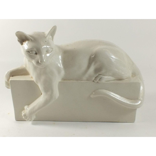 18 - A white porcelain cat on plinth, 25cm across